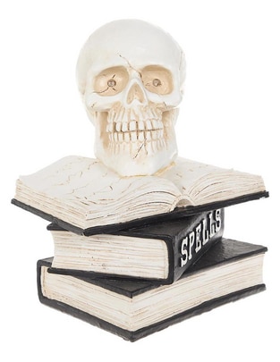 Figura decorativa de Halloween con forma de cráneo sobre libros