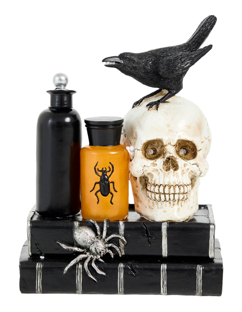 Figura decorativa de Halloween con forma de cráneo sobre libros 1
